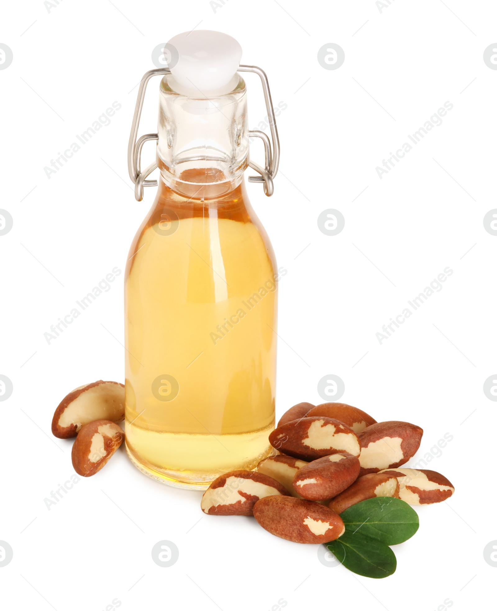 Photo of Tasty Brazil nuts and bottle with oil isolated on white