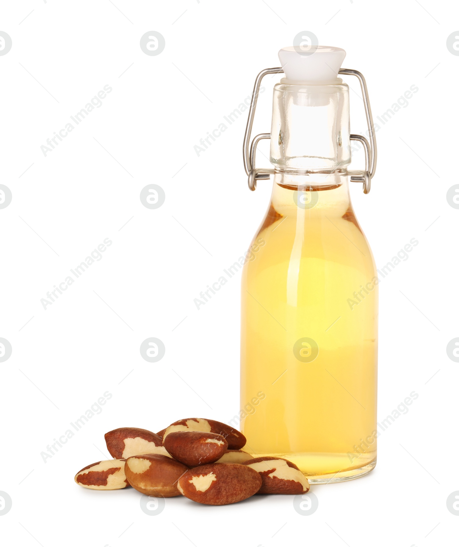 Photo of Tasty Brazil nuts and bottle with oil isolated on white