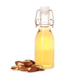 Photo of Tasty Brazil nuts and bottle with oil isolated on white