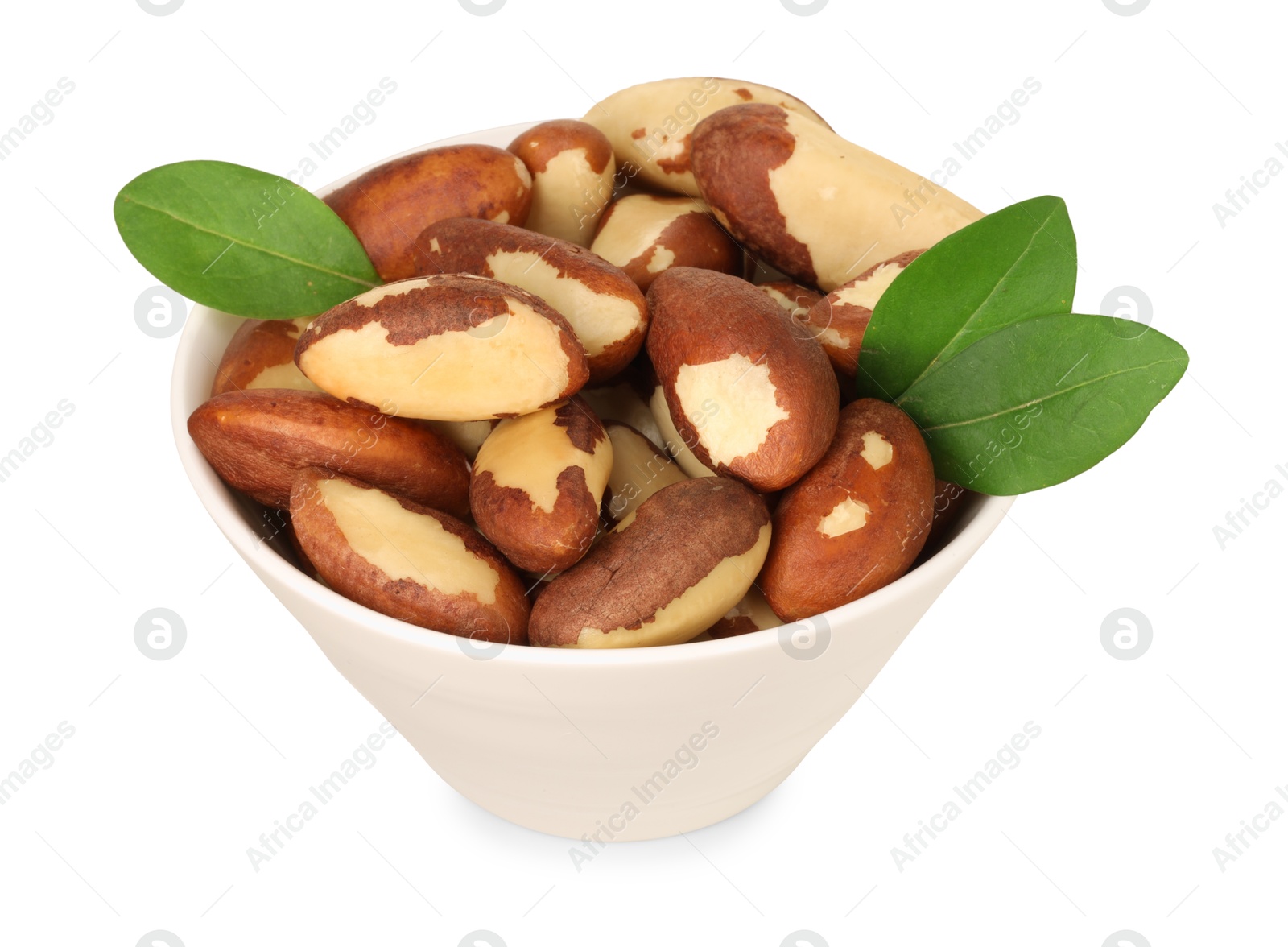 Photo of Tasty Brazil nuts and green leaves in bowl isolated on white