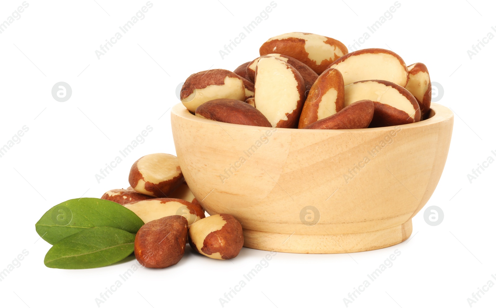 Photo of Tasty Brazil nuts in bowl and green leaves isolated on white