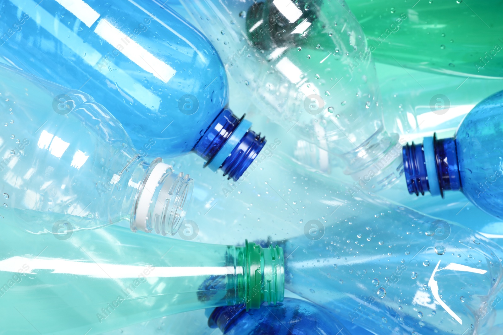 Photo of Many plastic bottles on light background, closeup