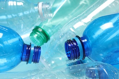 Photo of Many plastic bottles on light background, closeup