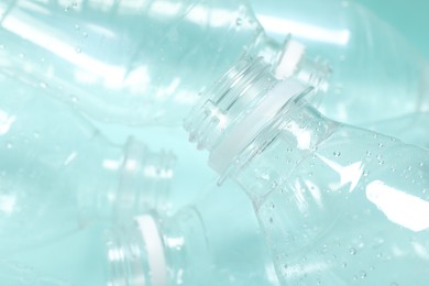 Photo of Many plastic bottles on light background, closeup