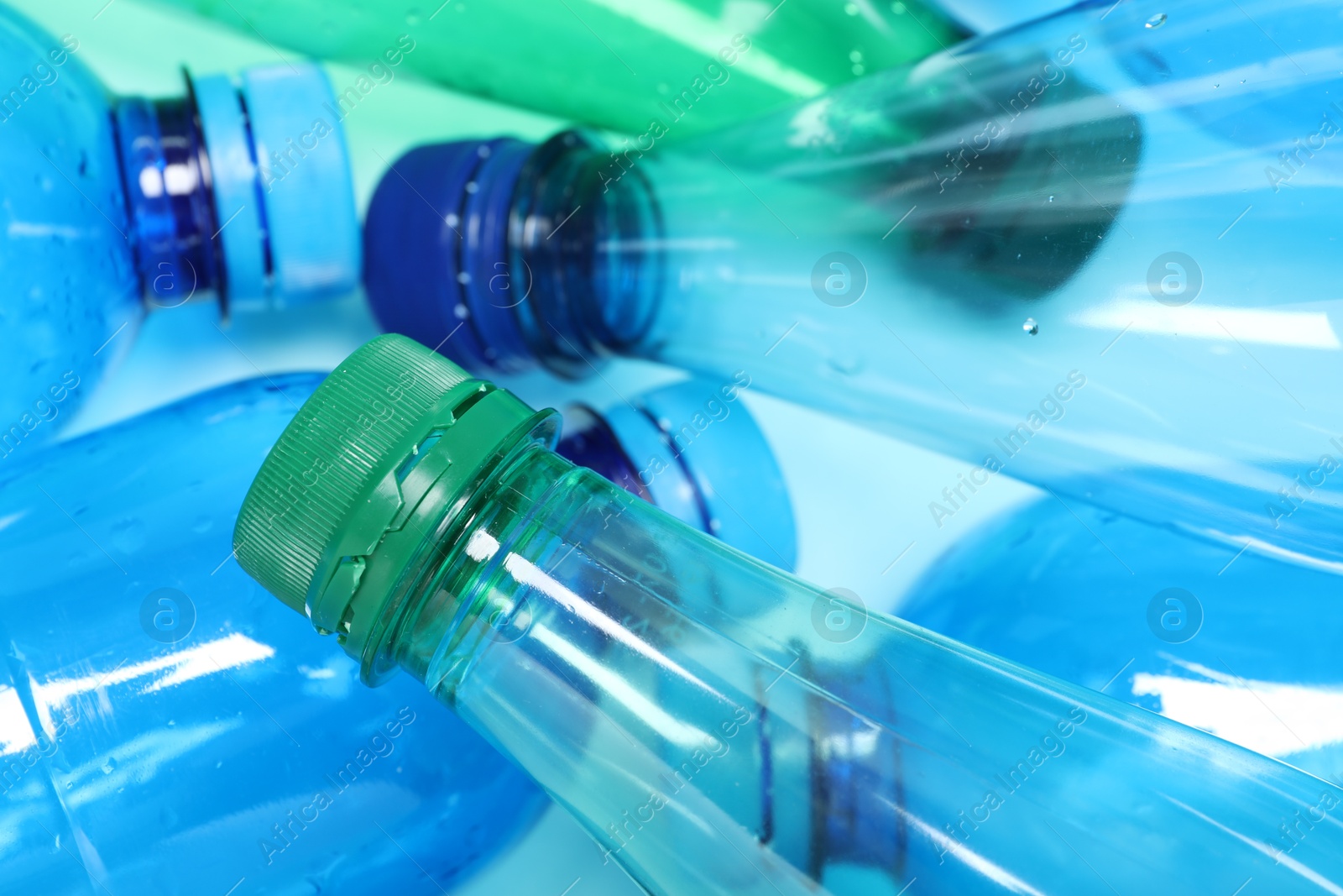 Photo of Many plastic bottles on light background, closeup