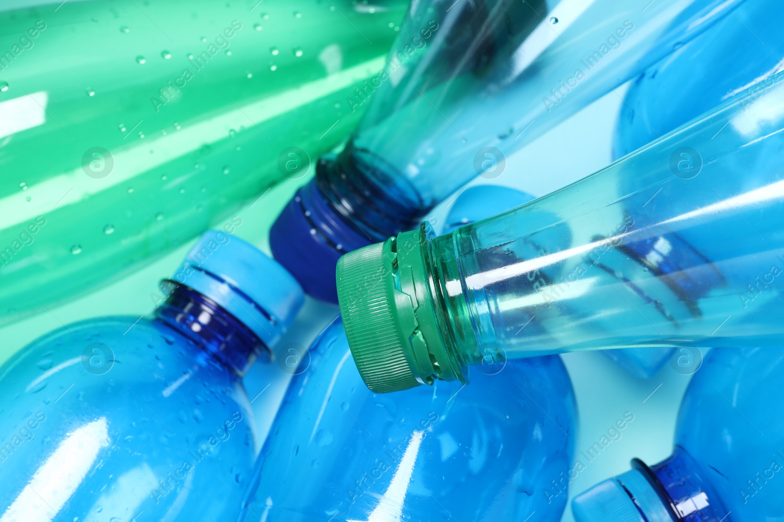 Photo of Many plastic bottles on light background, closeup