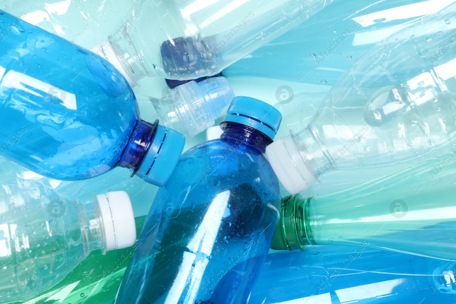 Photo of Many plastic bottles on light background, closeup