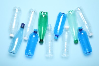 Photo of Many plastic bottles on light background, top view