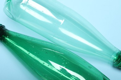 Photo of Plastic bottles on light background, top view