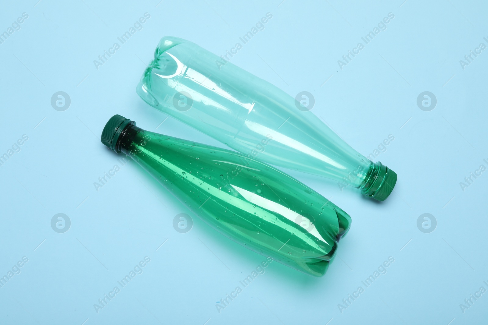 Photo of Plastic bottles on light background, top view