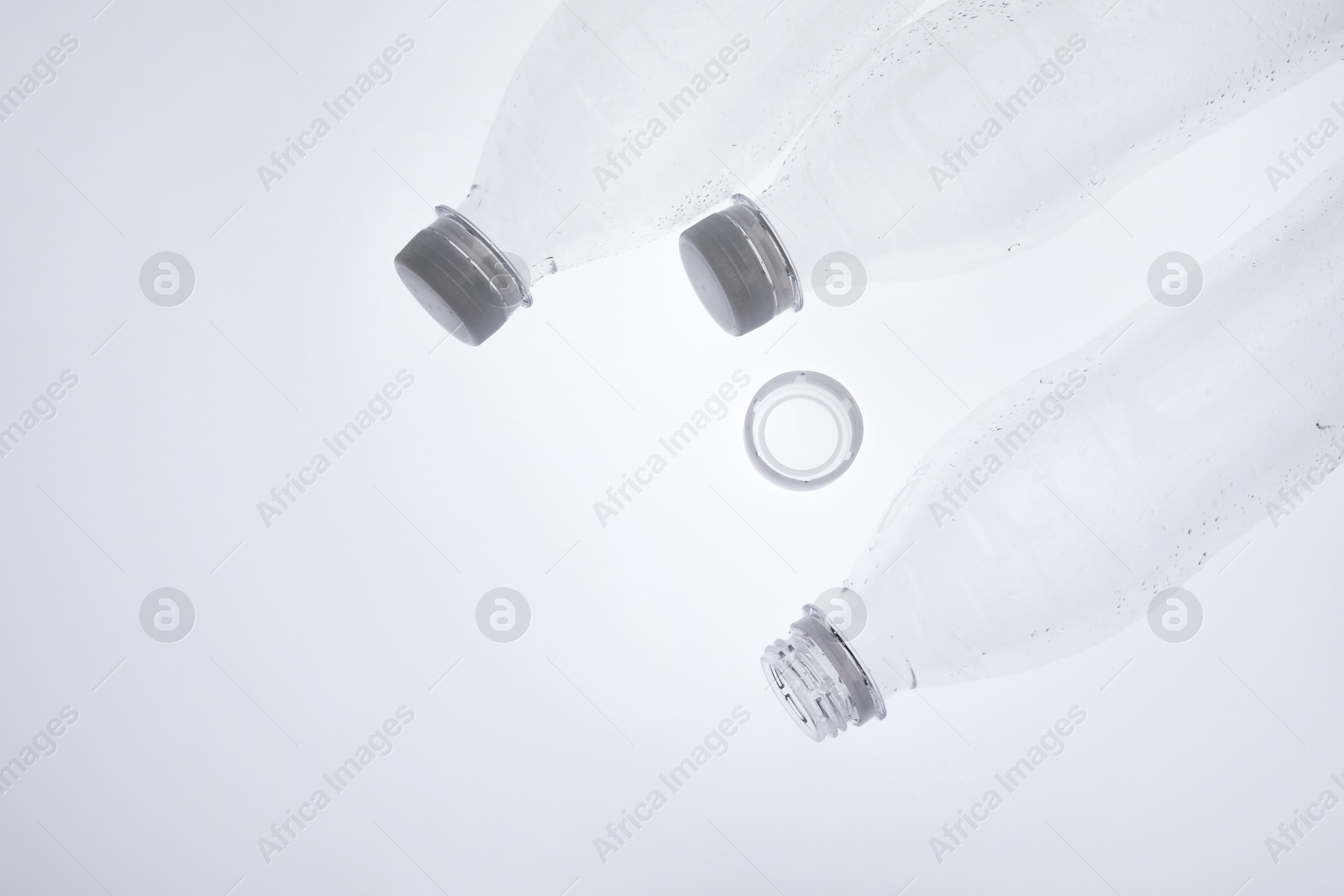 Photo of Empty plastic bottles on white background, top view. Space for text