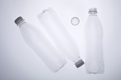 Photo of Empty plastic bottles on white background, top view