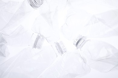 Photo of Crumpled plastic bottles on white background, closeup