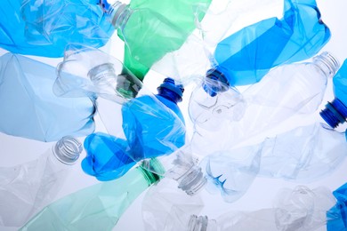 Photo of Crumpled plastic bottles on white background, closeup