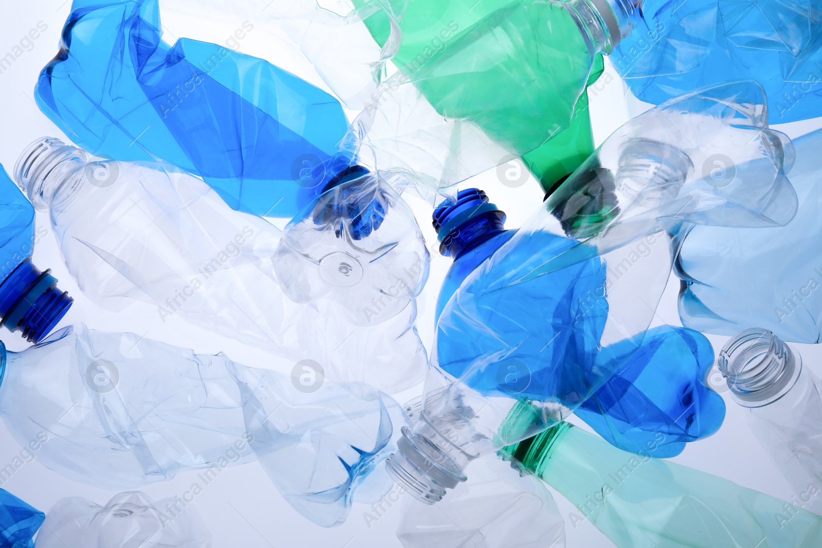 Photo of Crumpled plastic bottles on white background, closeup