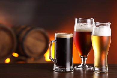 Photo of Glasses with different types of beer on wooden table in bar. Space for text