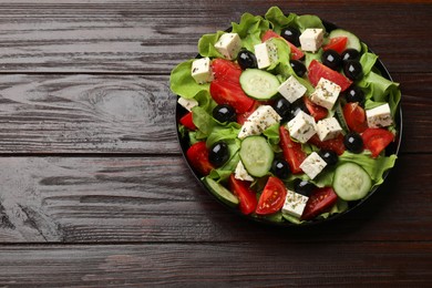 Photo of Delicious salad with feta cheese on wooden table, top view. Space for text