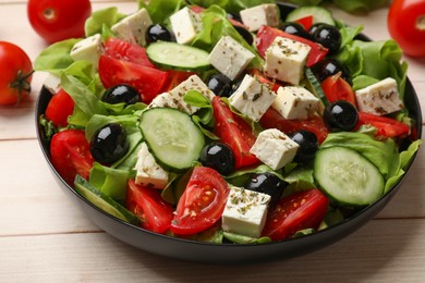 Photo of Delicious salad with feta cheese on white wooden table, closeup