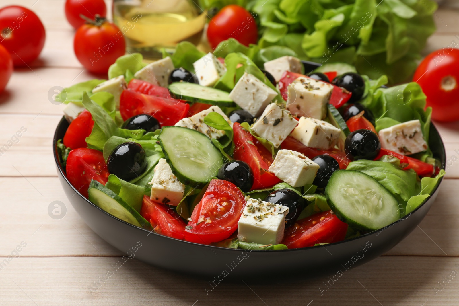 Photo of Delicious salad with feta cheese on white wooden table, closeup