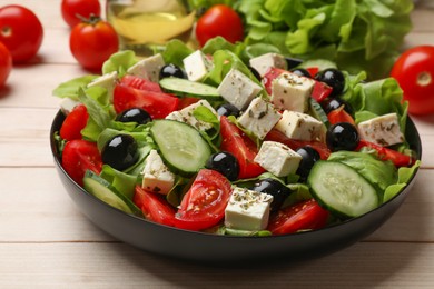 Photo of Delicious salad with feta cheese on white wooden table, closeup