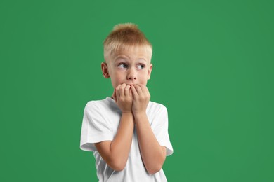 Photo of Portrait of scared little boy on green background