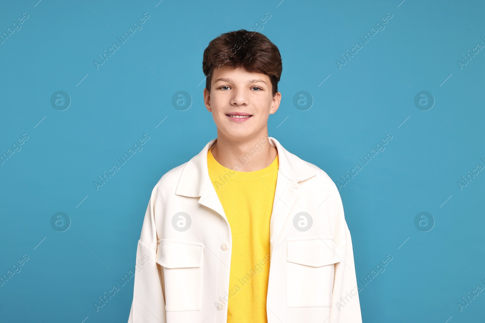 Photo of Portrait of teenage boy on light blue background