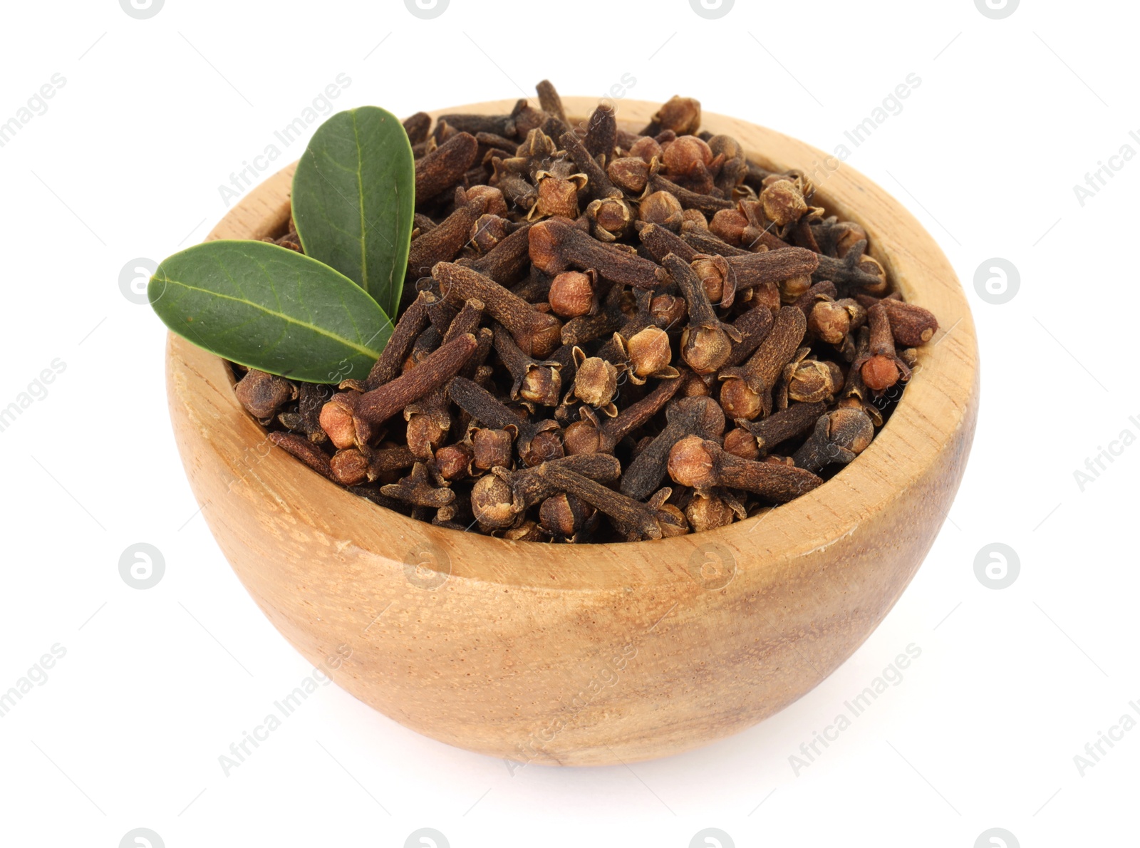 Photo of Dry clove buds and green leaves in wooden bowl on white background. Aromatic spice