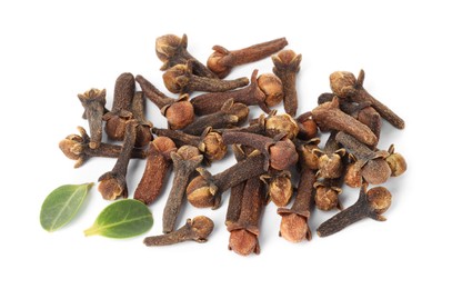 Photo of Pile of dry clove buds and green leaves on white background. Aromatic spice