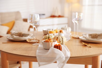 Stylish table setting with beautiful dishware and autumn decor in dining room