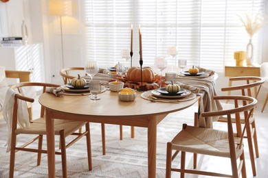 Photo of Stylish table setting with beautiful dishware and autumn decor in dining room