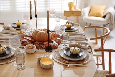 Stylish table setting with beautiful dishware and autumn decor in dining room