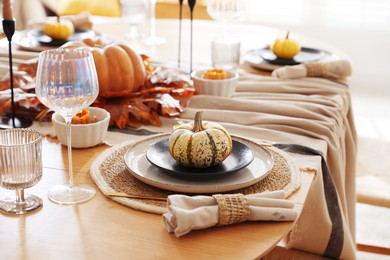 Stylish table setting with beautiful dishware and autumn decor in dining room