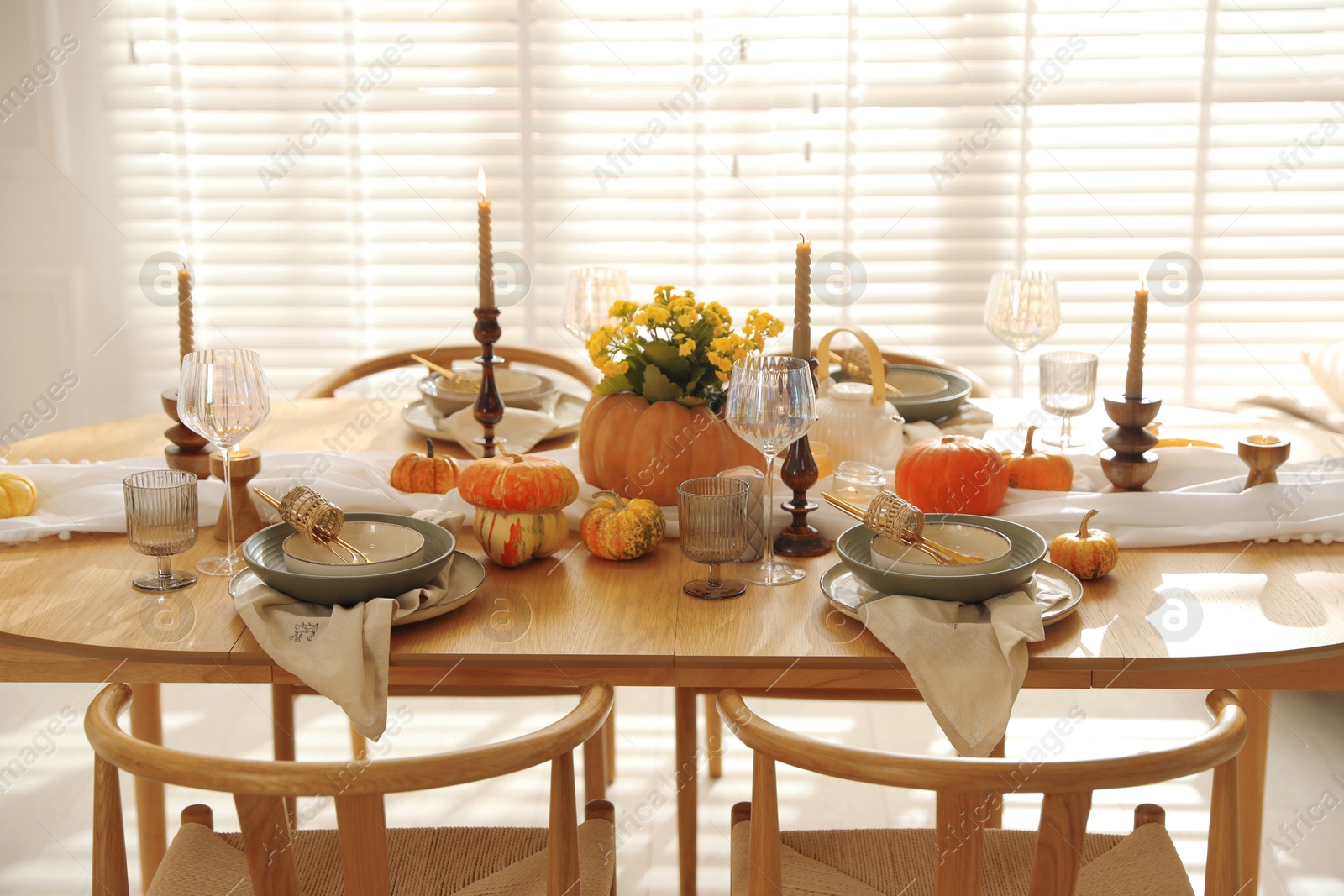 Photo of Stylish table setting with beautiful dishware, glasses and autumn decor in dining room