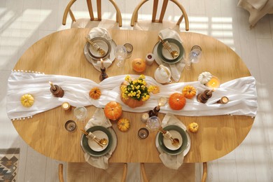 Photo of Stylish table setting with beautiful dishware, glasses and autumn decor in dining room, top view