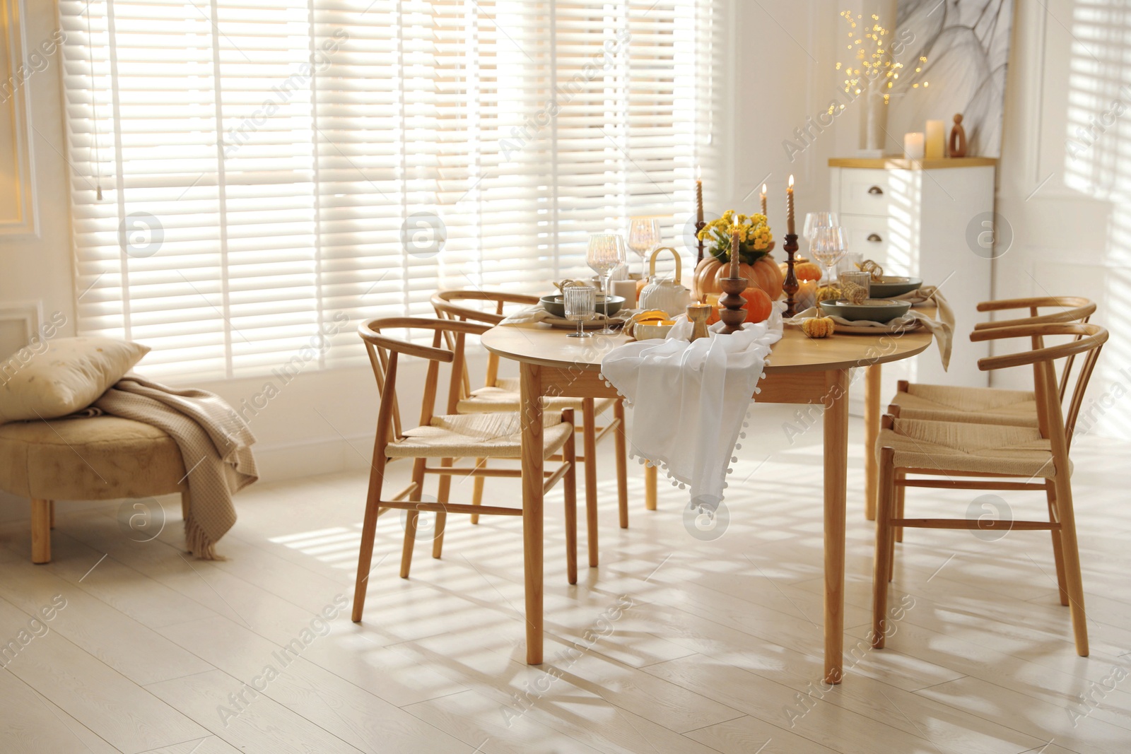 Photo of Stylish dining room with beautiful table setting and autumn decor