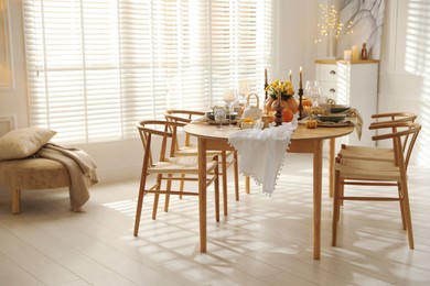 Stylish dining room with beautiful table setting and autumn decor