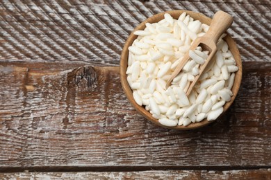 Photo of Puffed rice in bowl and scoop on wooden table, top view. Space for text