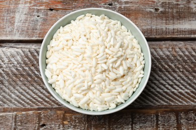 Photo of Puffed rice in bowl on wooden table, top view