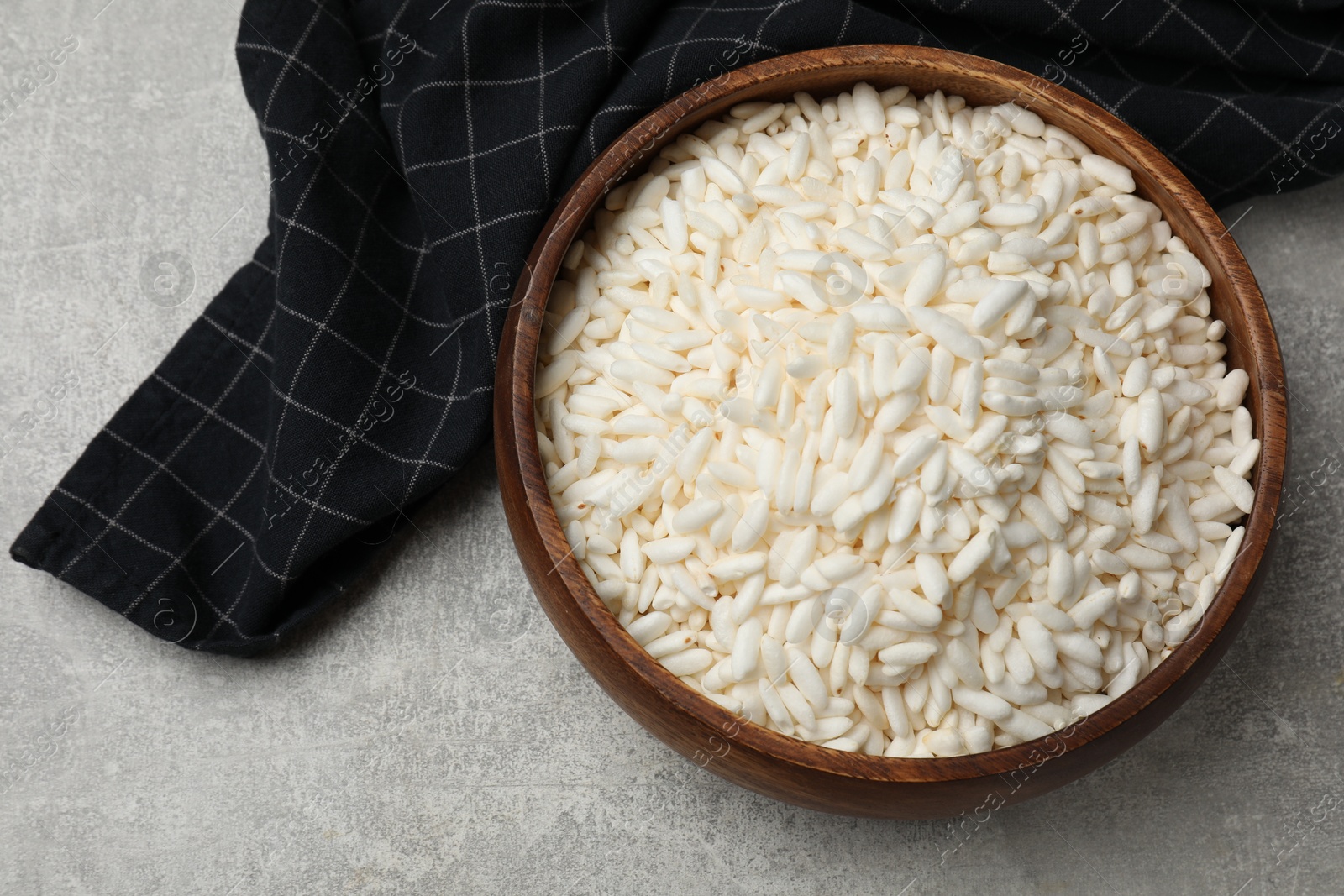 Photo of Puffed rice in bowl on light grey table, top view