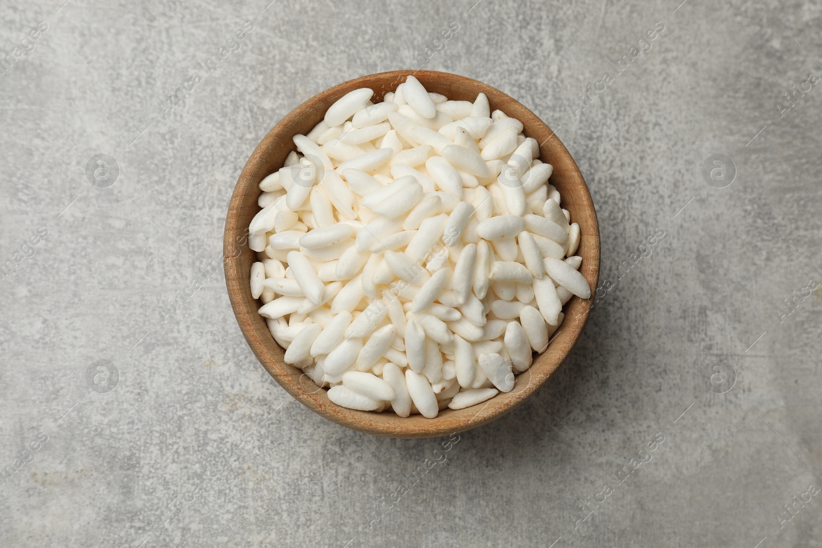 Photo of Puffed rice in bowl on light grey table, top view