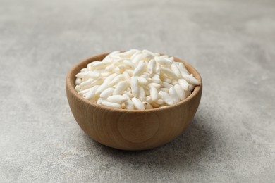 Photo of Puffed rice in bowl on light grey table, closeup