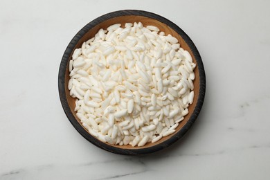 Photo of Puffed rice in bowl on white marble table, top view