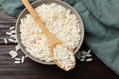 Photo of Puffed rice in bowl and spoon on wooden table, top view