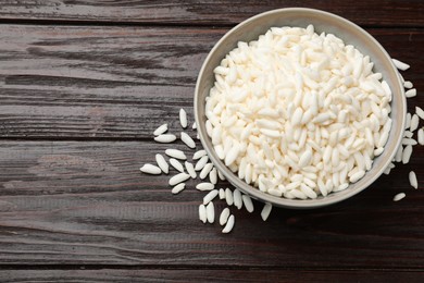 Photo of Puffed rice in bowl on wooden table, top view. Space for text