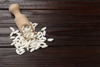 Photo of Puffed rice in scoop on wooden table, top view. Space for text