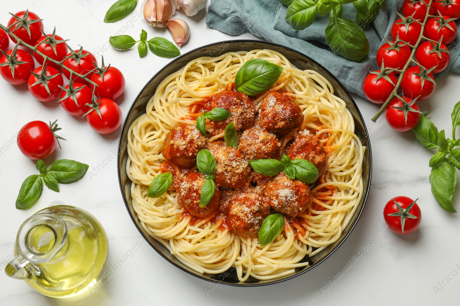 Photo of Delicious pasta with meatballs and ingredients on white marble table, flat lay