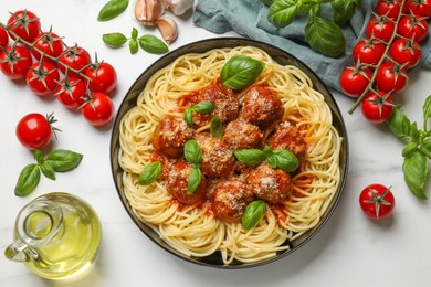 Delicious pasta with meatballs and ingredients on white marble table, flat lay