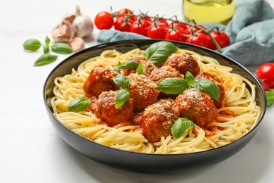 Delicious pasta with meatballs and ingredients on white marble table, closeup