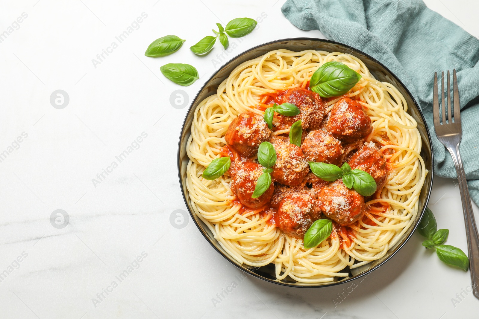 Photo of Delicious pasta with meatballs served on white marble table, flat lay. Space for text