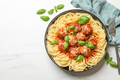 Delicious pasta with meatballs served on white marble table, flat lay. Space for text